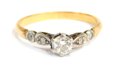 An 18ct gold diamond solitaire dress ring, with old cut diamond approx 0.12ct, in four claw setting with platinum band, platinum shoulders, on a yellow metal band, ring size Q, 2.3g all in.