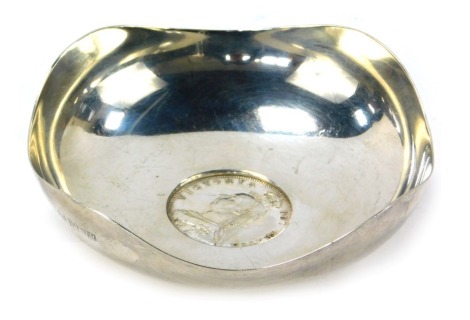 An Arts and Crafts bowl, formed with four points, and centred by a Victoria Britannia crown for 1887, white metal, unmarked, 2.75oz.