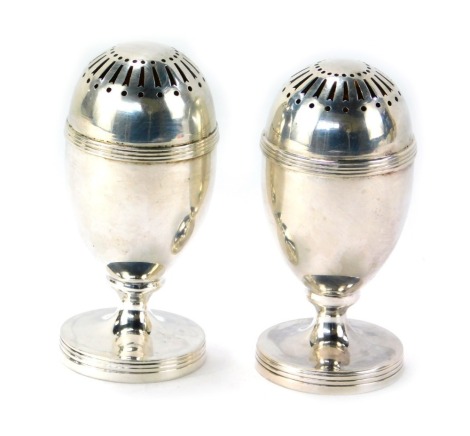 A pair of Victorian silver pepper pots, each with a domed and pierced top of egg shaped form, hallmarks rubbed possibly London, 2.59oz.