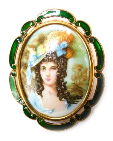 A TLM enamel brooch, the oval brooch depicting maiden in flowing blue dress, transfer printed design, with green enamel outer border, 4.5cm x 4cm, on brass mount.