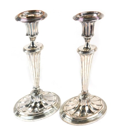 A pair of silver plated candlesticks, each on a shaped fan stem, on a stepped foot, 30cm high.