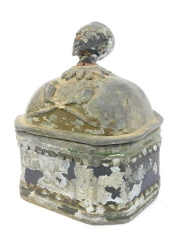 A 19thC lead tobacco jar, the lid cast with a male head above crossed clay pipes, some paint remaining, 17cm high.