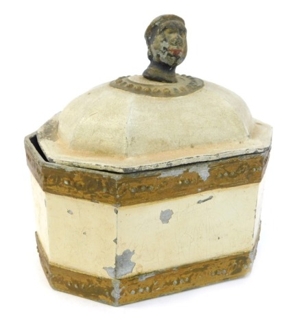 A 18thC lead tobacco jar, handled cast with the head of a man, later painted in cream and gold coloured paint, 14.5cm high.