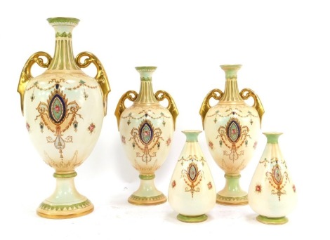 A group of Crown Devon blush pottery, comprising a graduated set of three two handled vases, the largest 39cm high, and two further vases, 15cm high, each piece decorated with flowers, swags, etc, gilt heightened, printed marks.