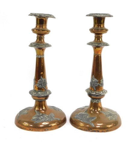 A pair of early 20thC copper and pewter candlesticks, each copper candlestick decorated with pewter flowers, unsigned, 28cm high.