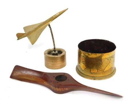 Trench Art, comprising a shell cased converted into a dish decorated with a band of ivy leaves, 9cm high, model of a plane, 20cm high, together with a wooden model propeller, marked V1044 REF 10A-3445, 34cm wide.