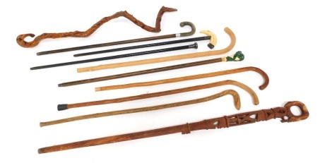 A group of walking sticks, to include a silver mounted ebonised stick, wooden walking sticks, a Classic Canes walking stick, the handle moulded with a figure of a frog, etc. (a quantity)