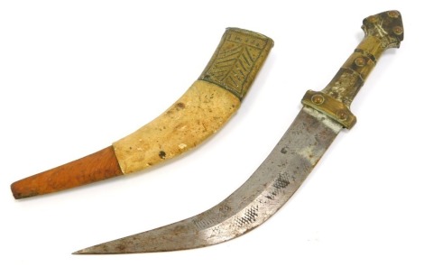 An Eastern dagger, with curved blade, scabbard decorated with embossed brass and animal skin, 34cm long, the blade 21cm long.