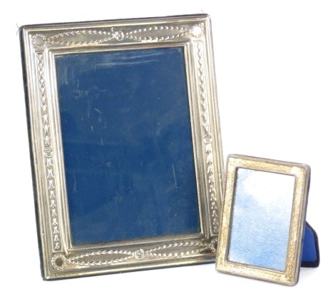 An Elizabeth II silver photograph frame, embossed with hair bells, Sheffield 1993, aperture 17cm x 12cm, frame 22.5cm x 17.5cm, and a further silver photograph frame, with a beaded rim, London 1988, aperture 8cm x 5.5cm frame 10.5cm x 8cm. (2)