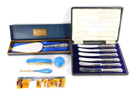 A George VI silver backed comb, Birmingham 1947, silver handled Kings pattern cake slice (boxed), six George V silver handled cake knives, cased, Sheffield 1915, and a gilt metal and blue guilloche enamel group of manicure implements, comprising buffer, c