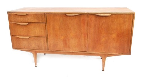 A McIntosh 1960's teak sideboard, with three graduated drawers, flanked by a pair of cupboard doors, opening to reveal a shaped shelf, raised on tapered legs, on brass feet, 76.5cm high, 152cm wide, 48.5cm deep.