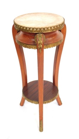 A Louis XVI style oak jardiniere stand, with a circular marbled top, and brass frame, raised on three scroll feet with brass mounts, united by a under tier, 69cm high, 34cm wide.