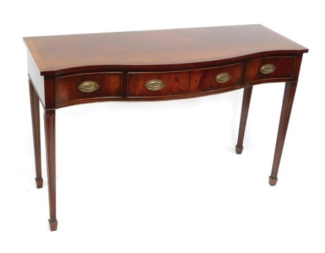 A Georgian reproduction mahogany serpentine serving table, with one long flanked by two short drawers, raised on channelled tapering square legs, over spade feet, 86cm high, 137cm wide, 51cm deep.