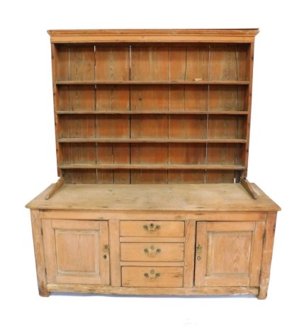 A Victorian pine dresser, with a four shelf plate rack, over three central drawers, flanked by two cupboard doors, raised on stiles, 185cm high, 170cm wide, 52.5cm deep.