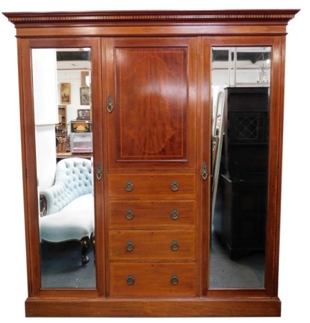 An Edwardian mahogany and line inlaid wardrobe, the top with a moulded edge above a central cupboard, above four short drawers flanked to either side by mirrored cupboard doors, on plinth base, 206cm high, 184cm wide, 54cm deep.