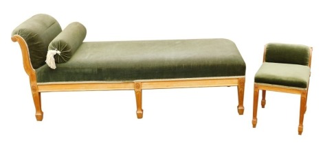 A 20thC oak chaise longue, with carved floral roundel decoration, upholstered in green velvet fabric, 156cm wide, together with a matching footstool.