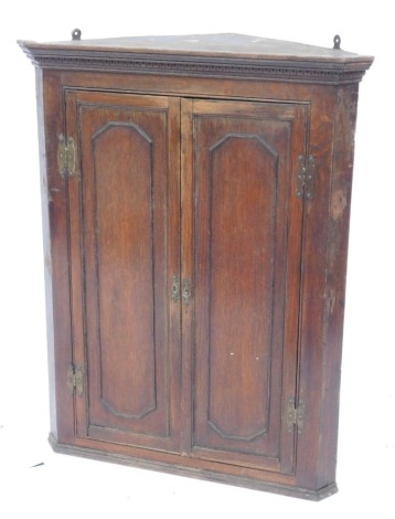 A 19thC oak hanging corner cabinet, the top with a moulded edge above two panelled doors, 98cm high, 73cm wide.