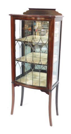 An Edwardian mahogany and line inlaid display cabinet, the top with a raised back above a moulded edge, with a leaded glazed door and two glass side panels enclosing three shelves, raised on splayed legs, with key, 147cm high, 63cm wide, 34cm deep.