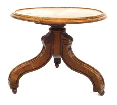 A late 19thC/early 20thC oak and burr wood side table, the circular top with a moulded edge above three carved legs on castors, adapted, 41cm high, 48cm diameter.