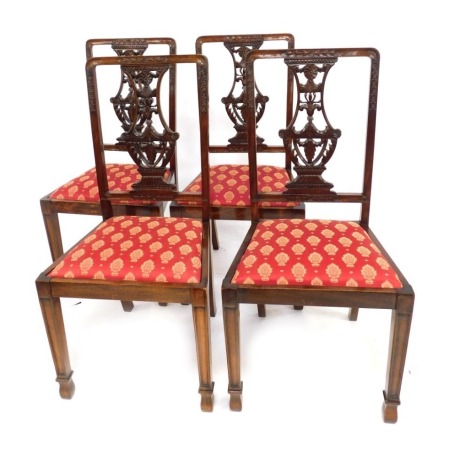 A set of four 20thC oak dining chairs, each with a pierced carved splat, drop in seat, on front turned legs.