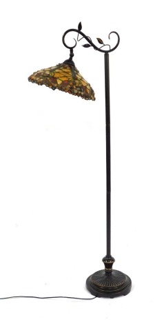 A Tiffany style standard lamp, the conical shade decorated in oranges, reds, etc, with applied stone decoration, 151cm high.