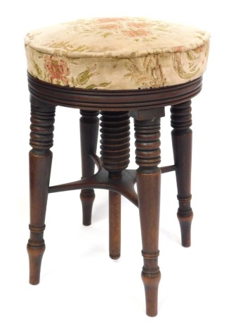 A Victorian mahogany and upholstered revolving piano stool, raised on ring turned legs, united by an X framed stretcher, 48cm high.