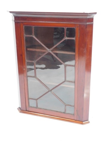 An Edwardian mahogany hanging corner display cabinet, with an out swept pediment over an astragal glazed door enclosing two shelves, 101.5cm high, 80cm wide, 46cm deep. (AF)