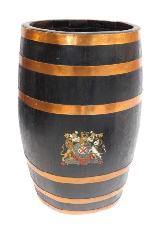 An oak and copper bound barrel stick stand, bearing a coat of arms with four castles towers, with lion and unicorn supporters, 61cm high.