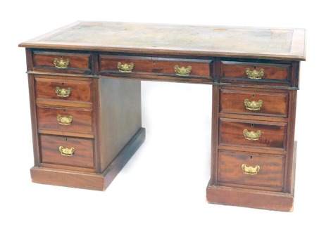 A late Victorian mahogany twin pedestal desk, the top with a gilt tooled leather skiver, above one long and eight short graduated drawers, raised on plinth bases, 76cm high, 137cm wide, 77.5cm deep.