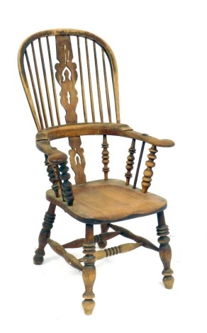 A Victorian oak and elm lath back kitchen chair, with a carved splat, solid saddle seat, raised on turned legs united by double H frame stretcher, 64cm wide.