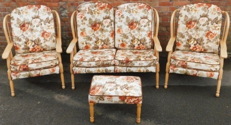 A light beech four piece cottage suite, with floral upholstered cushions, comprising a two seater sofa, 110cm wide, a pair of armchairs.