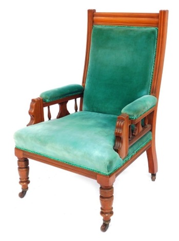 An Edwardian mahogany open armchair, with turquoise velvet over stuffed seat, back and arms, on front turned legs, on castors.