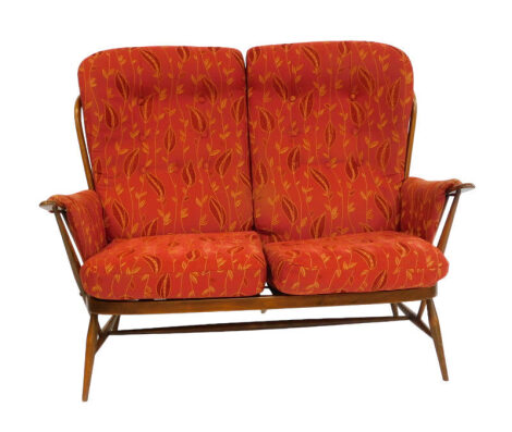 An Ercol elm two seater Windsor sofa, with red foliate fabric, button back cushions, seat cushions and arm rests, 135cm wide.