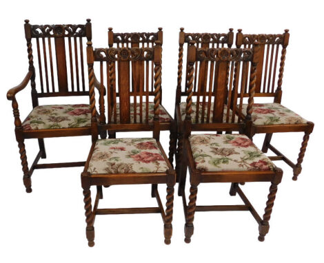 A set of six 17thC style oak dining chairs, with floral and foliate carved crest rail, floral pattern drop in seats, raised on barley twist legs, united by an H framed stretcher, comprising a carver chair and five single chairs. (6)