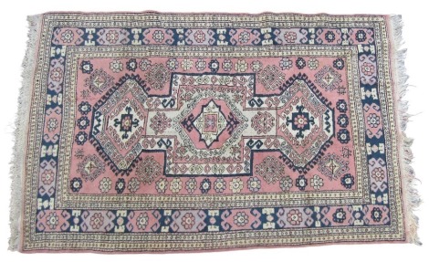 A Kilim pink ground rug, the central geometric fields set with three large and two smaller medallions, within a ground with further medallions and flowers, and a repeating floral borders, 222cm x 147cm.