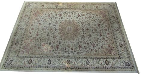 A Kashmir cream ground rug, decorated with a central medallion, flowers and scrolling leaves, within a repeating floral and foliate border, 340cm x 239cm.