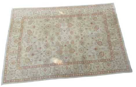 A Caucasian green ground rug, decorated with floral and foliate motifs, within repeating floral borders, 297cm x 204cm.