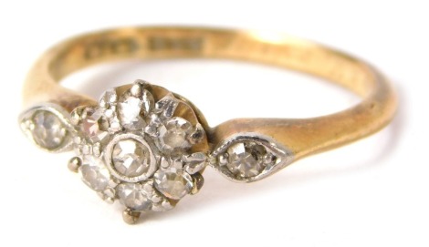 An 18ct gold and plat diamond cluster ring, the central cluster set with tiny diamonds in claw and rub over setting with two tiny diamond set borders, set in platinum on a yellow metal band, inscribed NM2BN 29-4-16, ring size L½, 2.6g all in.