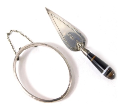 A silver child's hinged bangle, 5.5cm wide, and a miniature silver and agate handled presentation trowel, 8cm long, 13.2g all in. (2)