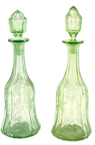 A pair of green glass mallet shaped decanters and stoppers, each engraved with grapes and vines, 35cm high.