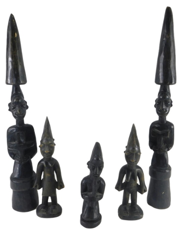 A pair of African ebonised wood tribal figures, each with a tusk shaped top and three further small figures. (5)