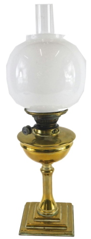 A late Victorian brass oil lamp, with opaque glass shade and chimney, the base 35cm high.