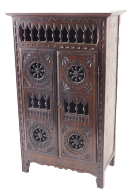 A 20thC French country made miniature armoire, with spindle turned and carved decoration, 46cm high, 25cm wide.