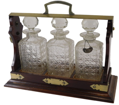 A mahogany and silver plated tantalus, with square sectioned decanters and stoppers, etc., 39cm wide.