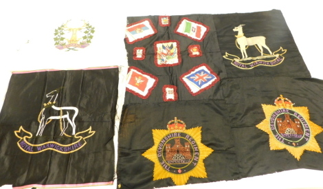 A quantity of large hand embroidered military badges, to include Devonshire regiment, the Royal Warickshire, etc.