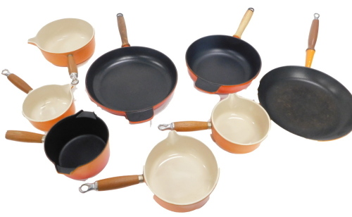 Various orange Le Crueset pans.