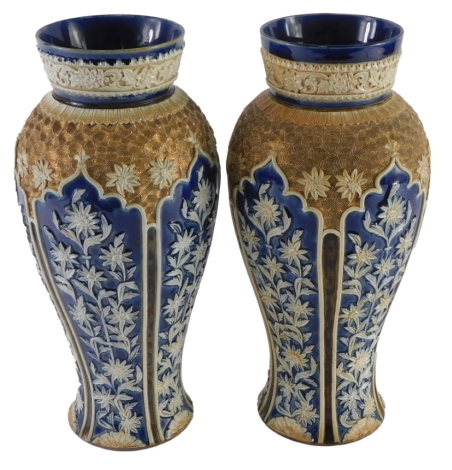 A near pair of Doulton Lambeth stoneware vases, each decorated in gilt and in cobalt blue, 28cm high.