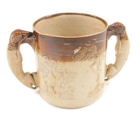 An early 20thC Doulton stoneware loving cup, in brown treacle glaze with greyhound handles, 14cm high.