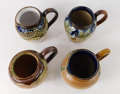 Four miniature Doulton Lambeth stoneware jugs, varying patterns, 9cm high. (4) - 2