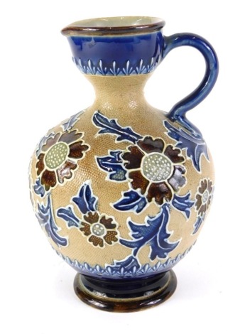 A Royal Doulton Slaters Patent jug or ewer, decorated with flowers and leaves with tube lining, on a beige ground within cobalt blue borders, impressed marks to underside, decorator's initials MP, 14cm high.